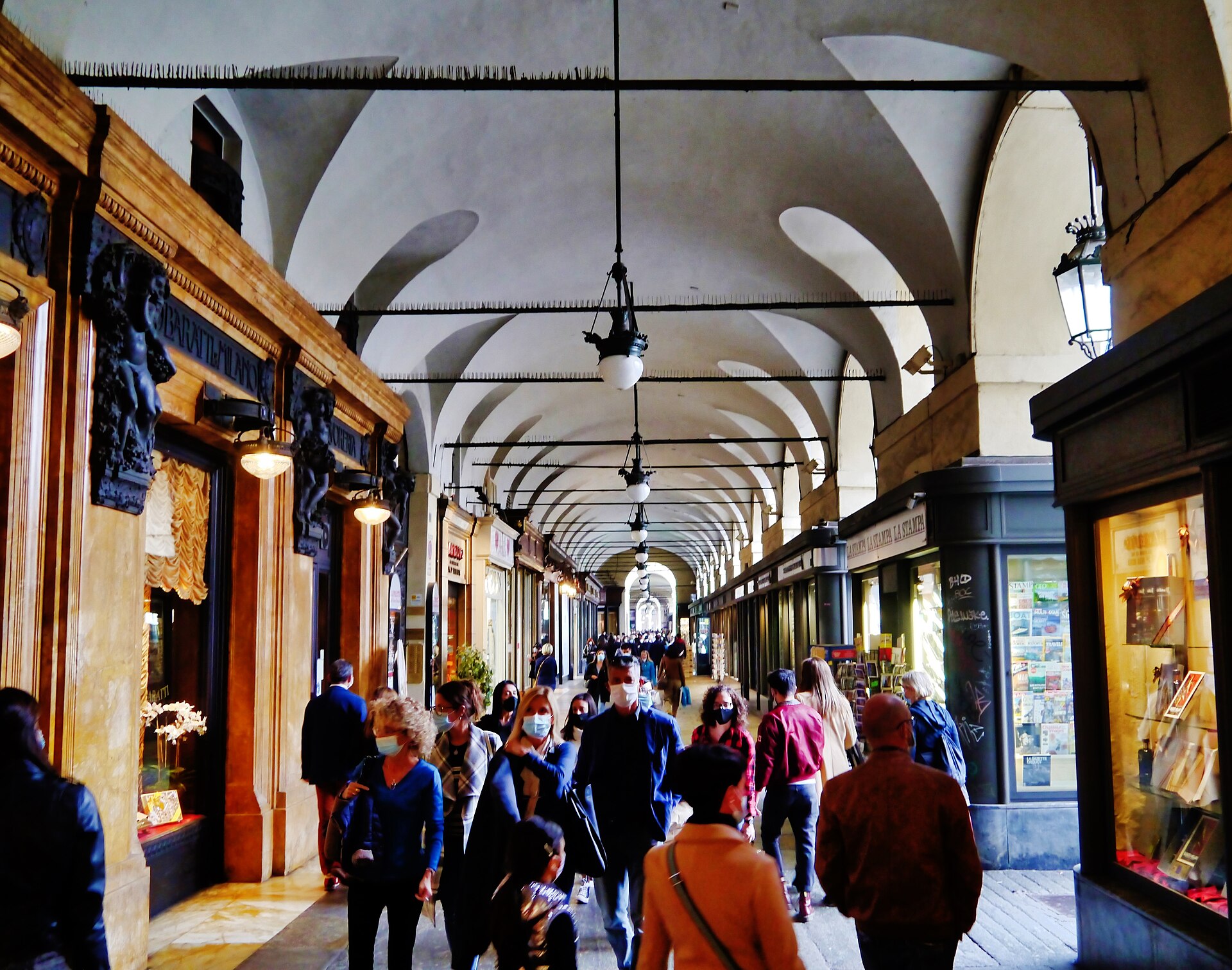 Portici di Torino con negozi e passanti